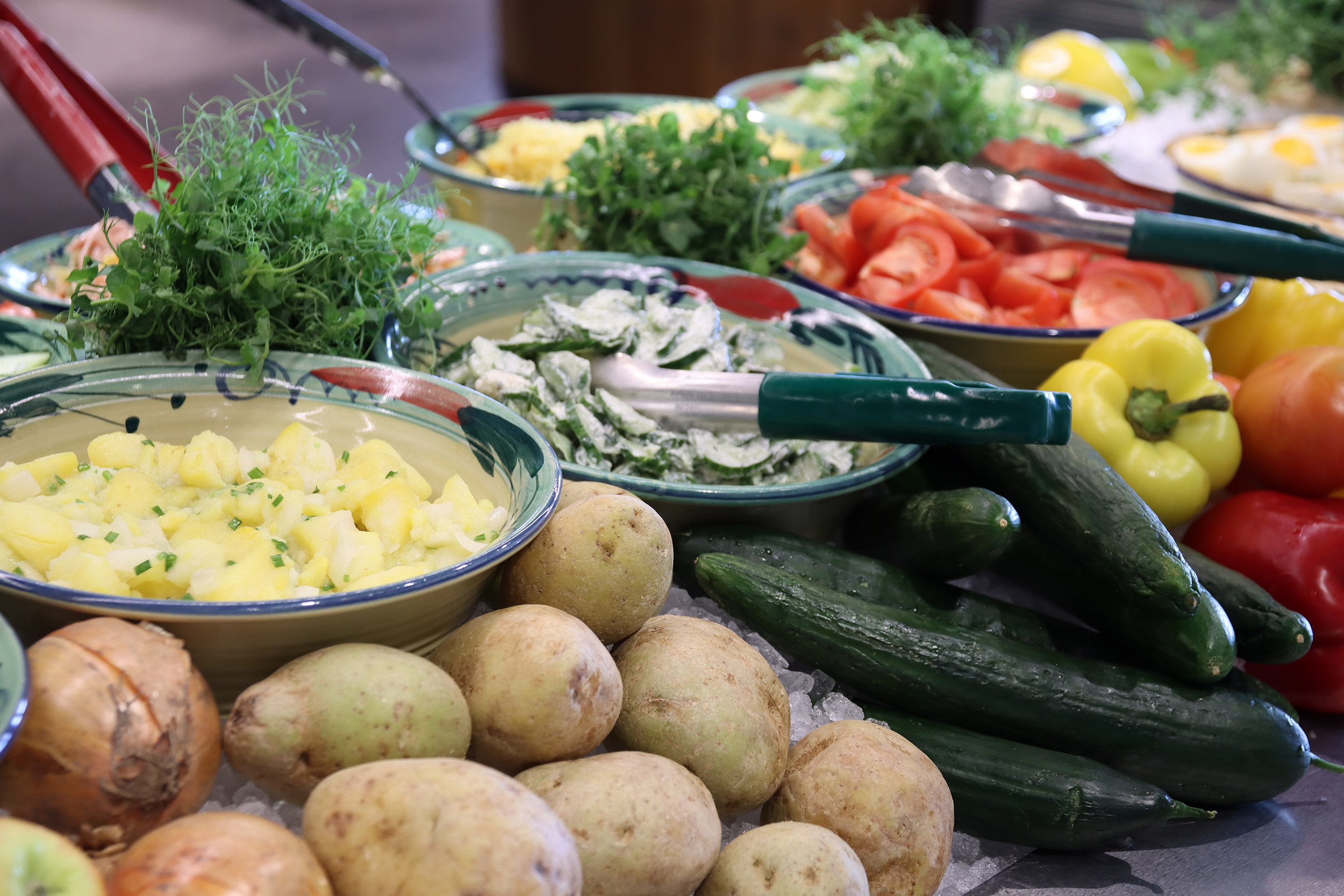 Marche_Wörthersee_Salatschüsseln_Buffet_Gemüse Buffet Salatschüsseln mit frischen Kartoffeln, Gurken und Paprika und Kräutertöpfen Marché Wörthersee